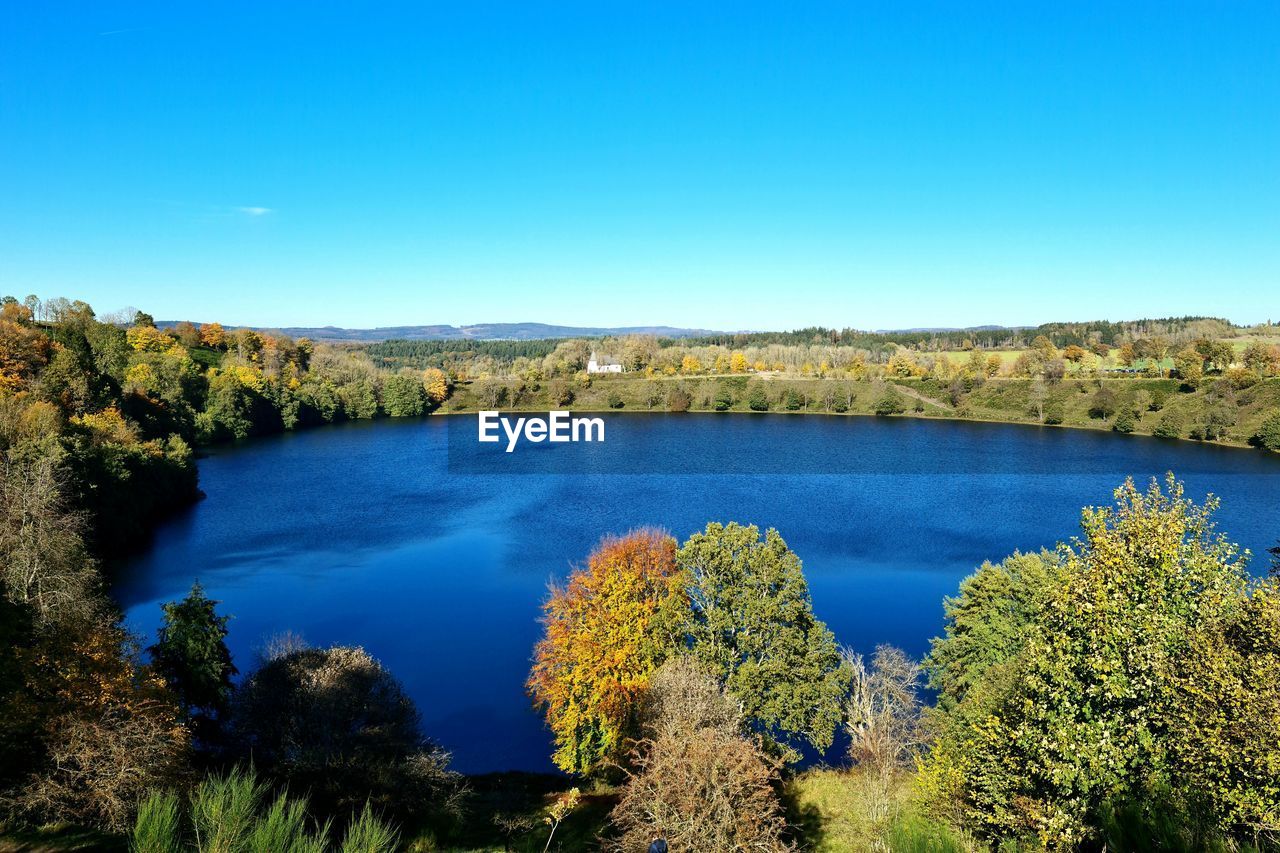SCENIC VIEW OF RIVER BY TREES AGAINST BLUE SKY