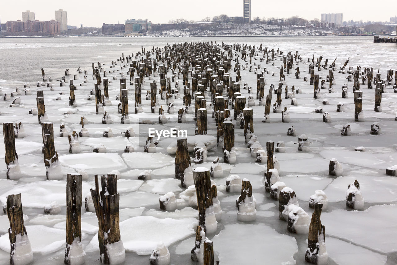 High angle view of wooden posts in frozen river