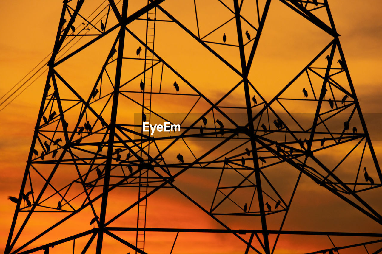 LOW ANGLE VIEW OF POWER LINES AGAINST SKY AT SUNSET