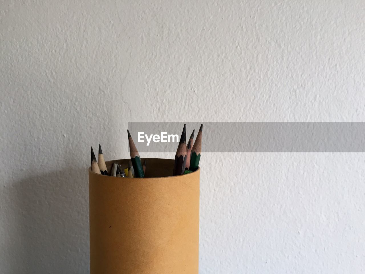 Close-up of pencil on table against wall