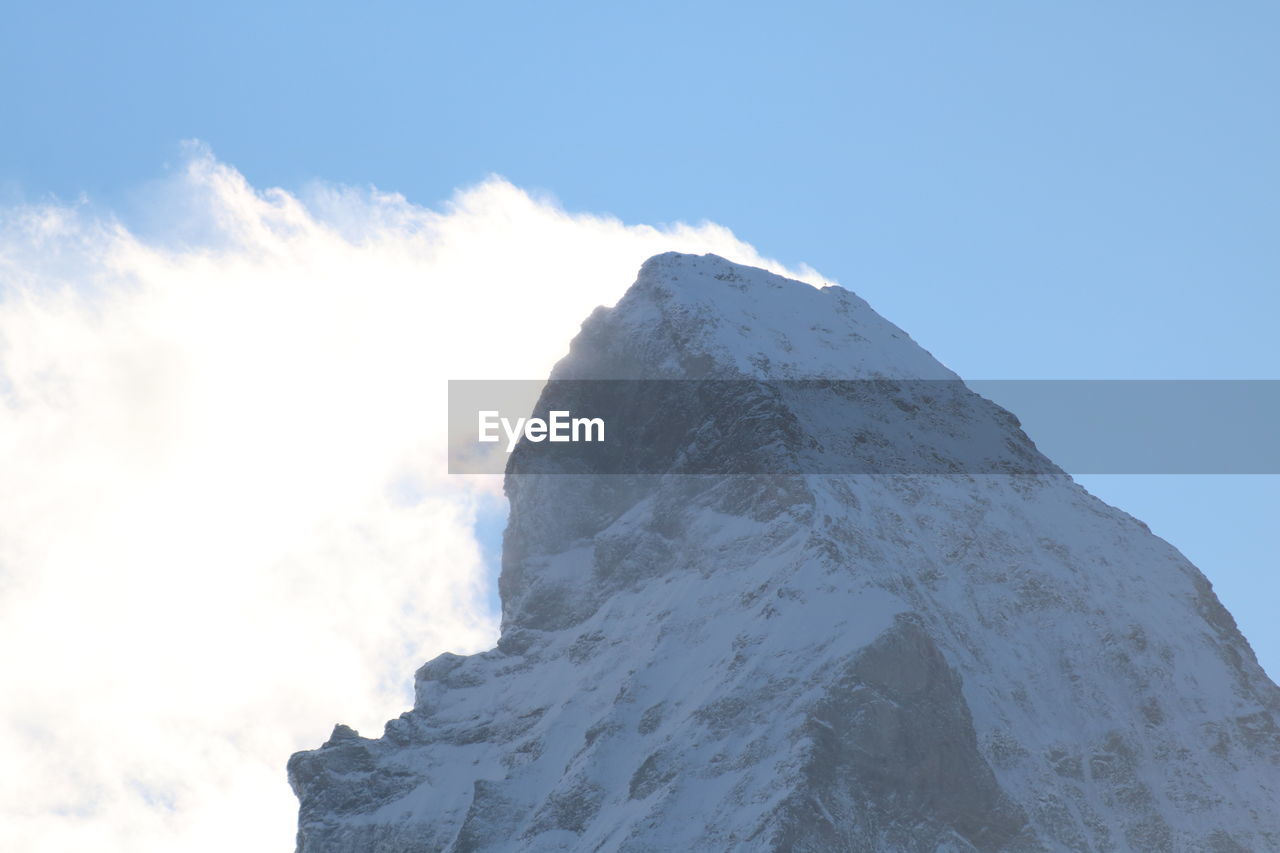 sky, mountain, mountain range, cloud, beauty in nature, scenics - nature, nature, environment, landscape, snow, mountain peak, summit, blue, mountaineering, cold temperature, ridge, winter, rock, travel destinations, day, outdoors, travel, no people, tranquility, low angle view, sunlight, tranquil scene, non-urban scene, adventure, sunny, white, snowcapped mountain, tourism, plateau, idyllic, geology, climbing, mountain climbing