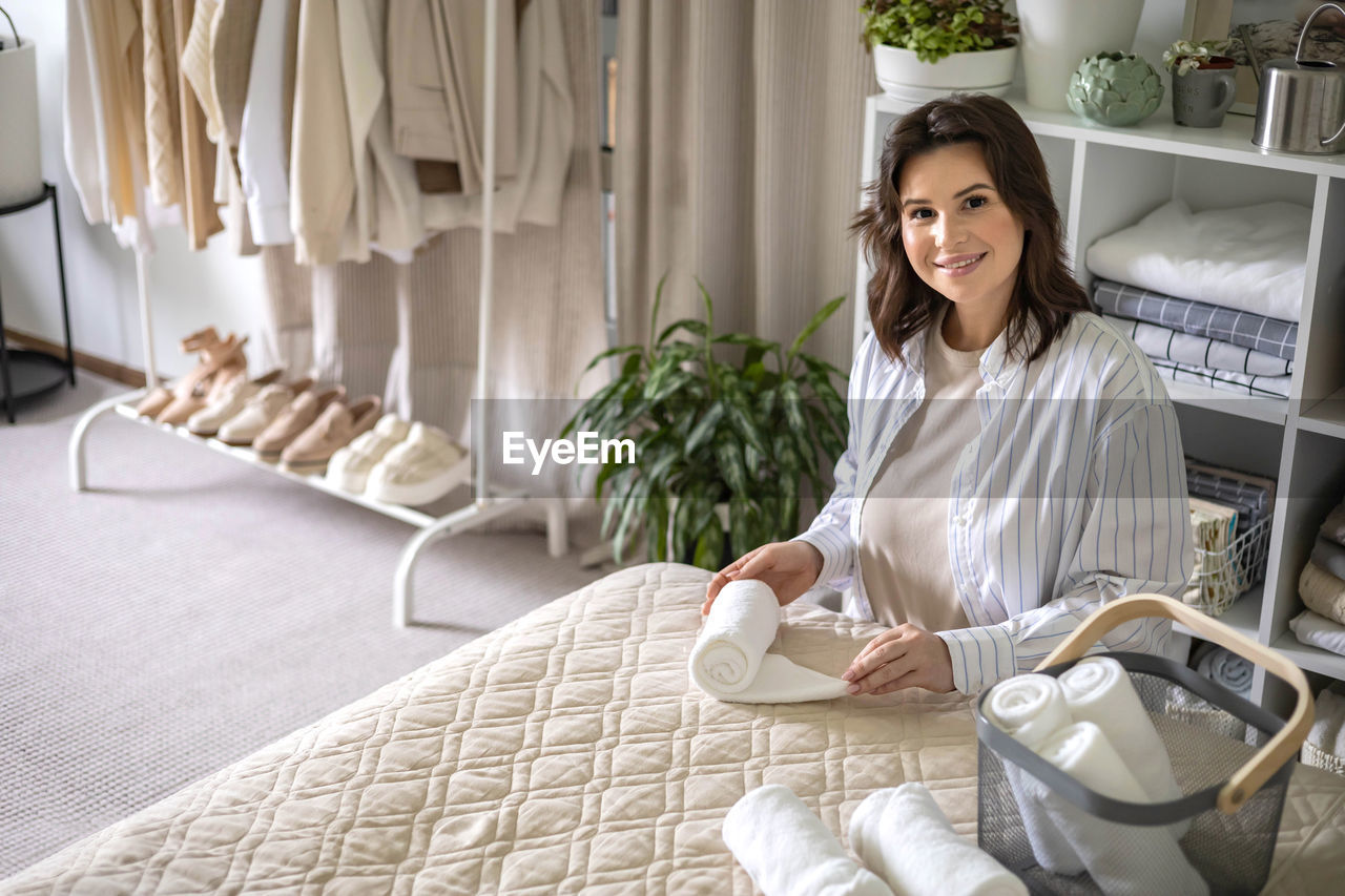 portrait of young woman sitting on bed