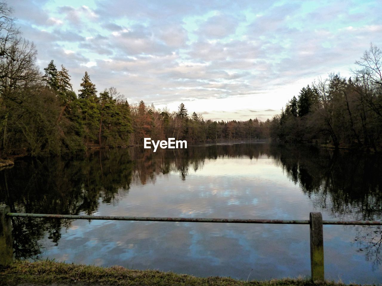 REFLECTION OF TREES ON LAKE AGAINST SKY