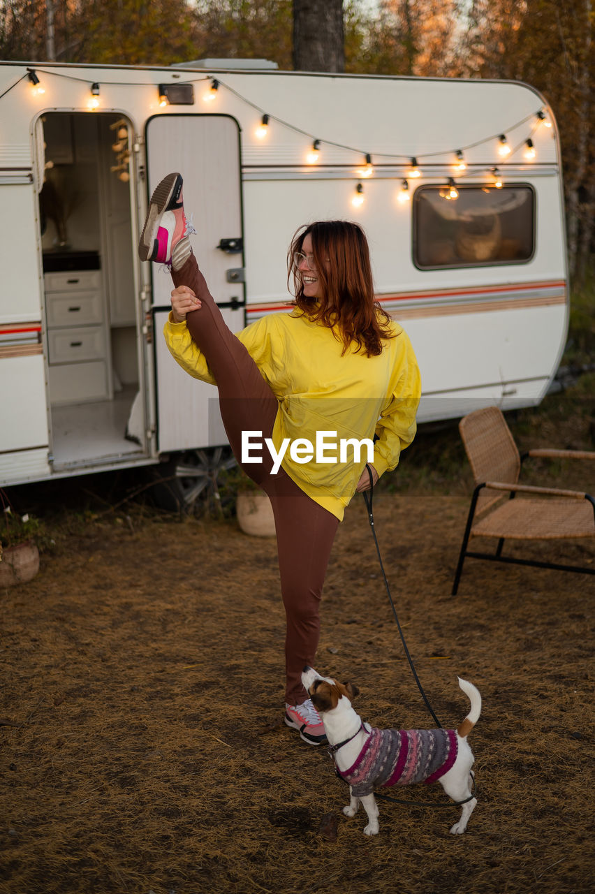 A red-haired caucasian woman stands in a twine against the background of a motor home. traveling on