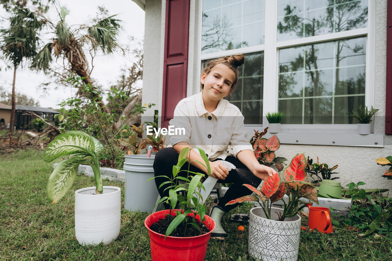 Portrait of smiling girl  surrounded by potted plant