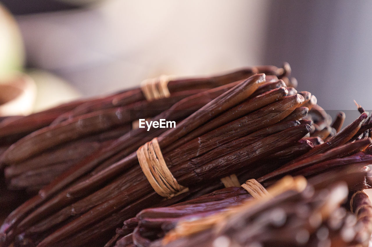 Full frame close up on bundles of vanilla beans on a market stall.