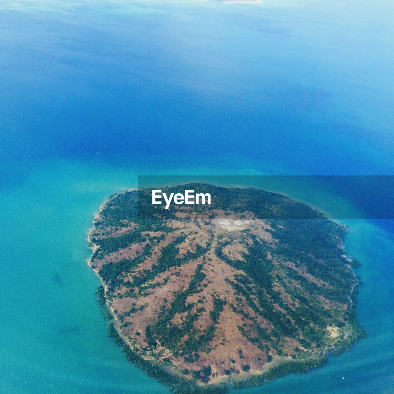 High angle view of island amid calm blue sea