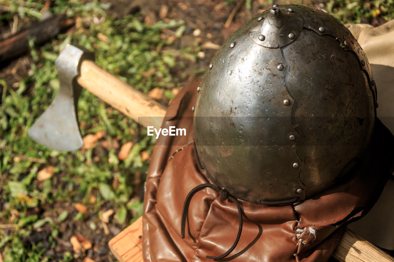 High angle view of helmet and axe on field