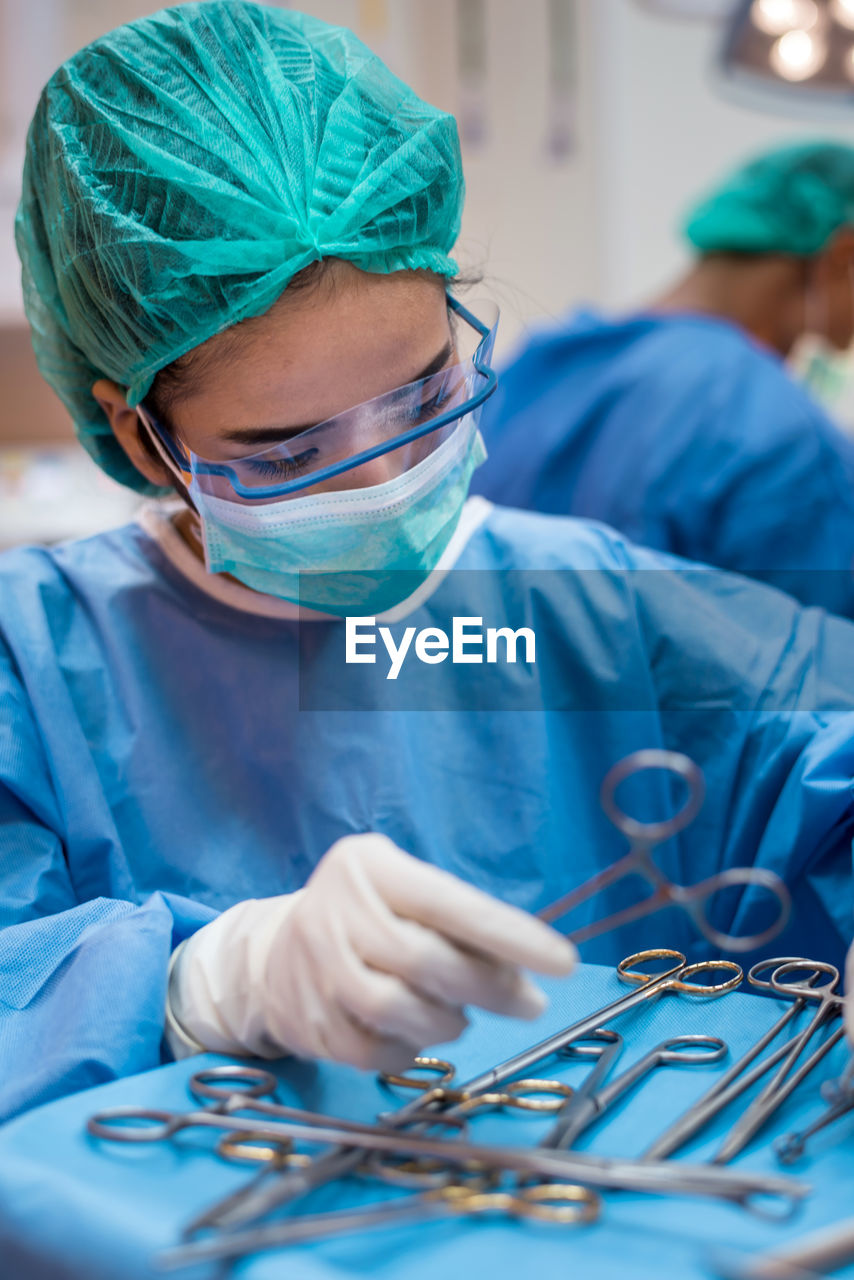 Doctor holding surgical equipment on table