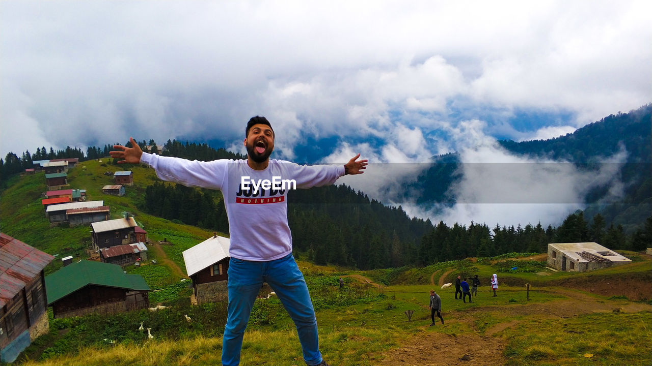 Man with arms outstretched standing on mountain