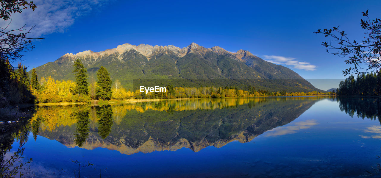 reflection, nature, water, mountain, scenics - nature, lake, beauty in nature, tree, sky, wilderness, autumn, landscape, mountain range, environment, plant, tranquility, tranquil scene, forest, blue, land, no people, travel destinations, morning, travel, pine tree, outdoors, non-urban scene, coniferous tree, leaf, idyllic, pinaceae, activity, pine woodland, cloud, tourism, mountain peak, body of water, woodland, yellow