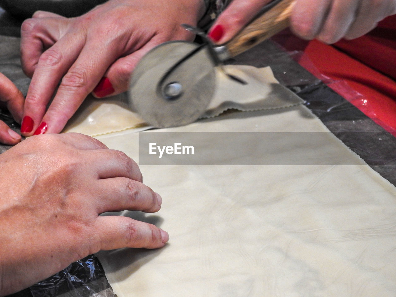 Cropped image of couple making pasta kitchen