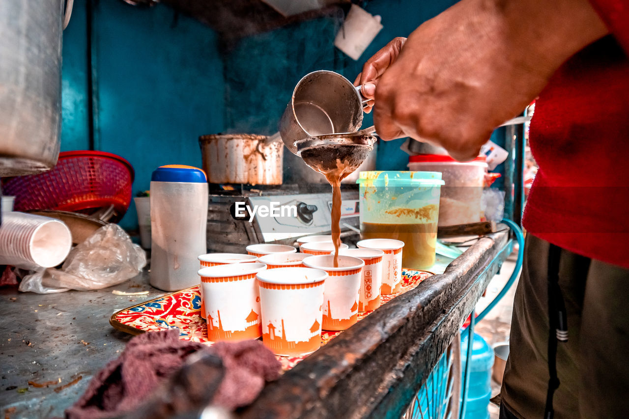 MIDSECTION OF MAN WORKING IN CONTAINER AT MARKET