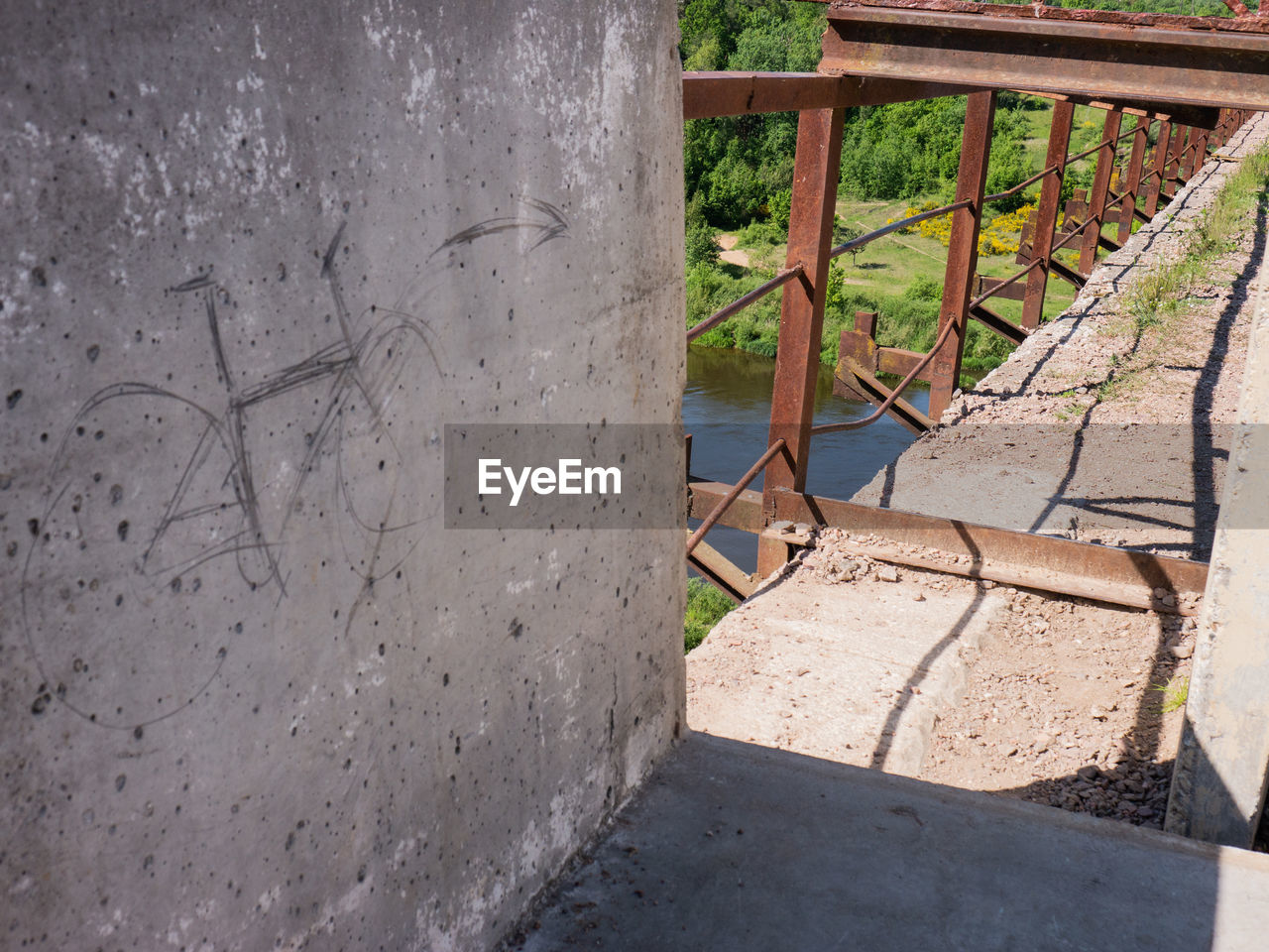 HIGH ANGLE VIEW OF EMPTY BENCH AGAINST WALL