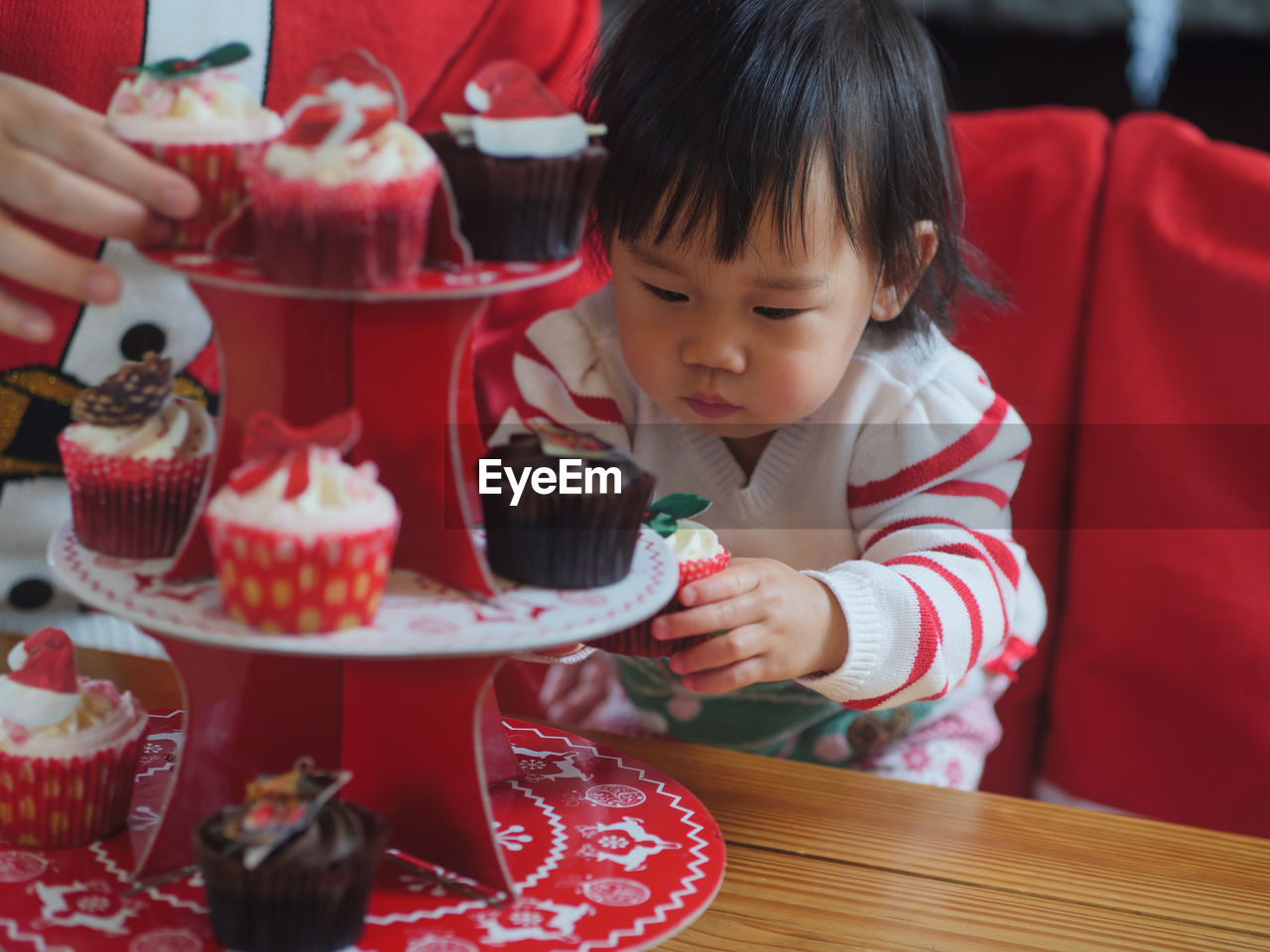 Baby girl having cupcake at table