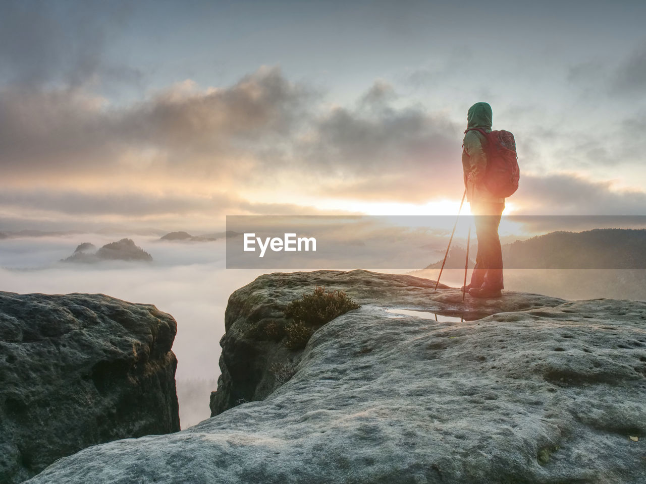 View from sharp cliff into mystery misty landscape. woman enjoy the deep silence.