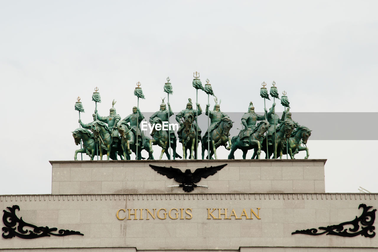 LOW ANGLE VIEW OF STATUE AGAINST WALL