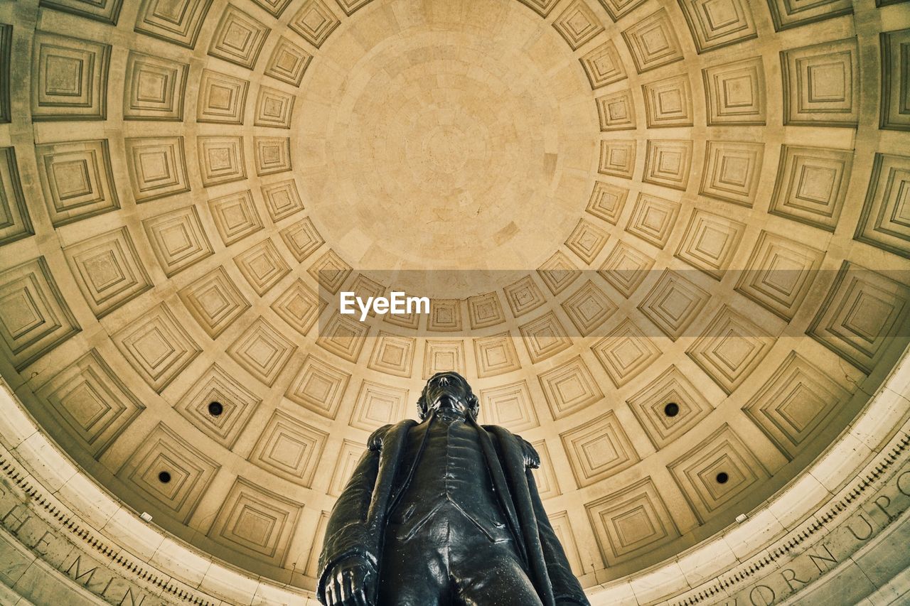 Low angle view of statue against cupola at thomas jefferson memorial