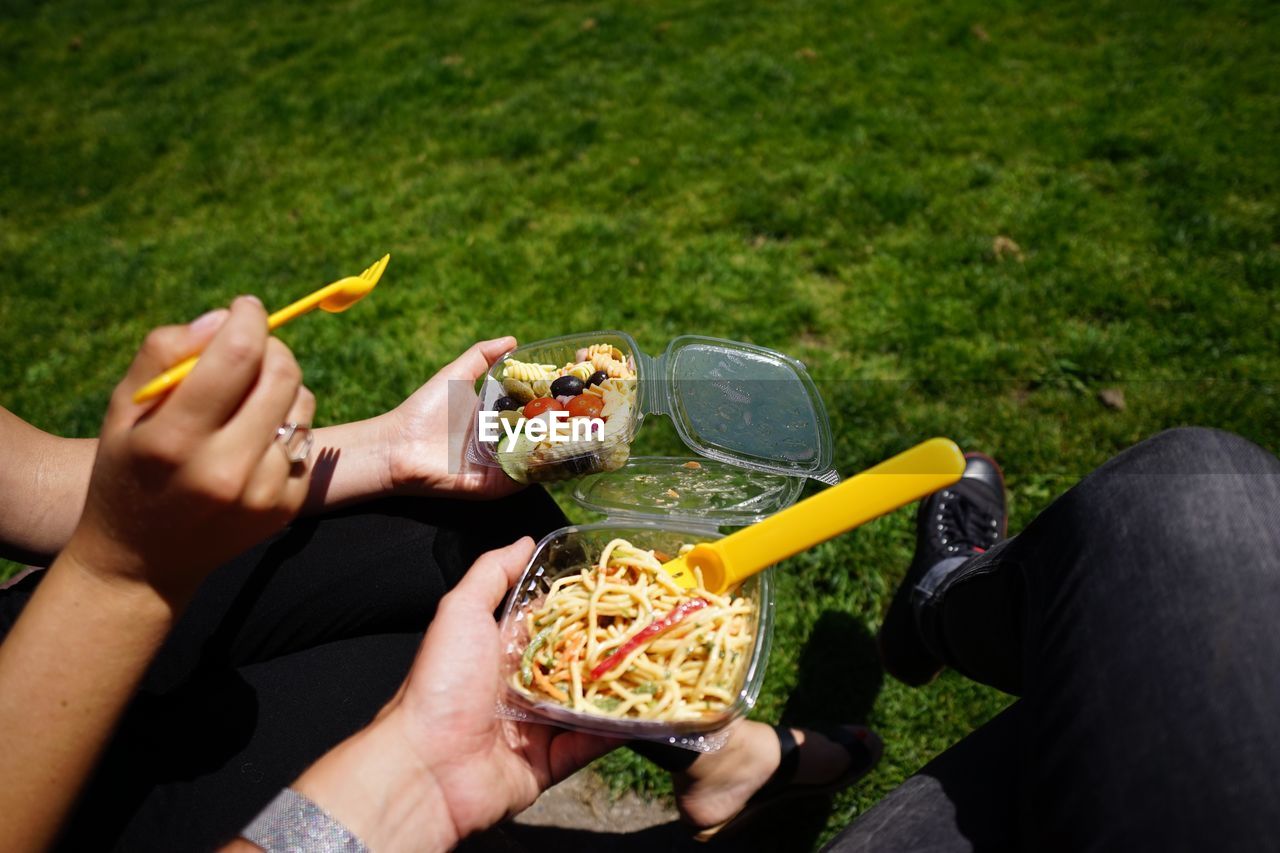 Cropped image of people eating food at park