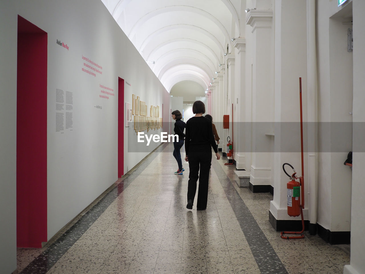 PEOPLE WALKING IN CORRIDOR OF BUILDING