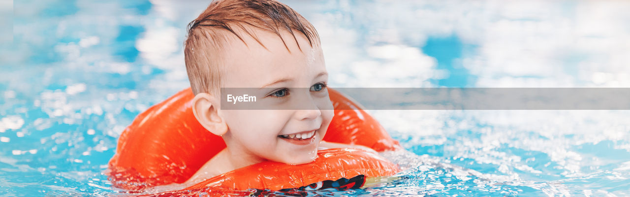 Smiling cute boy in swimming pool