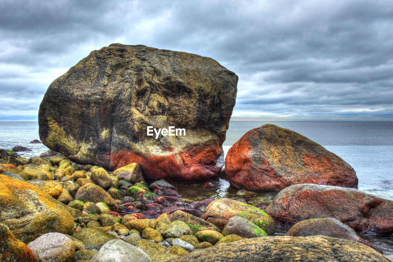 Rock formation on beach against sky