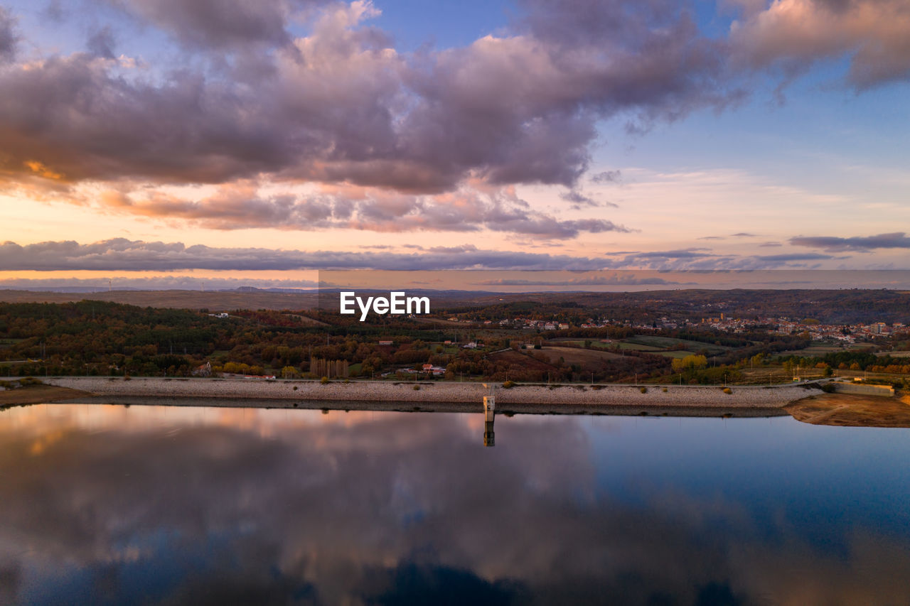 Drone aerial view of a lake reservoir of a dam with reflection on the water in sabugal, portugal