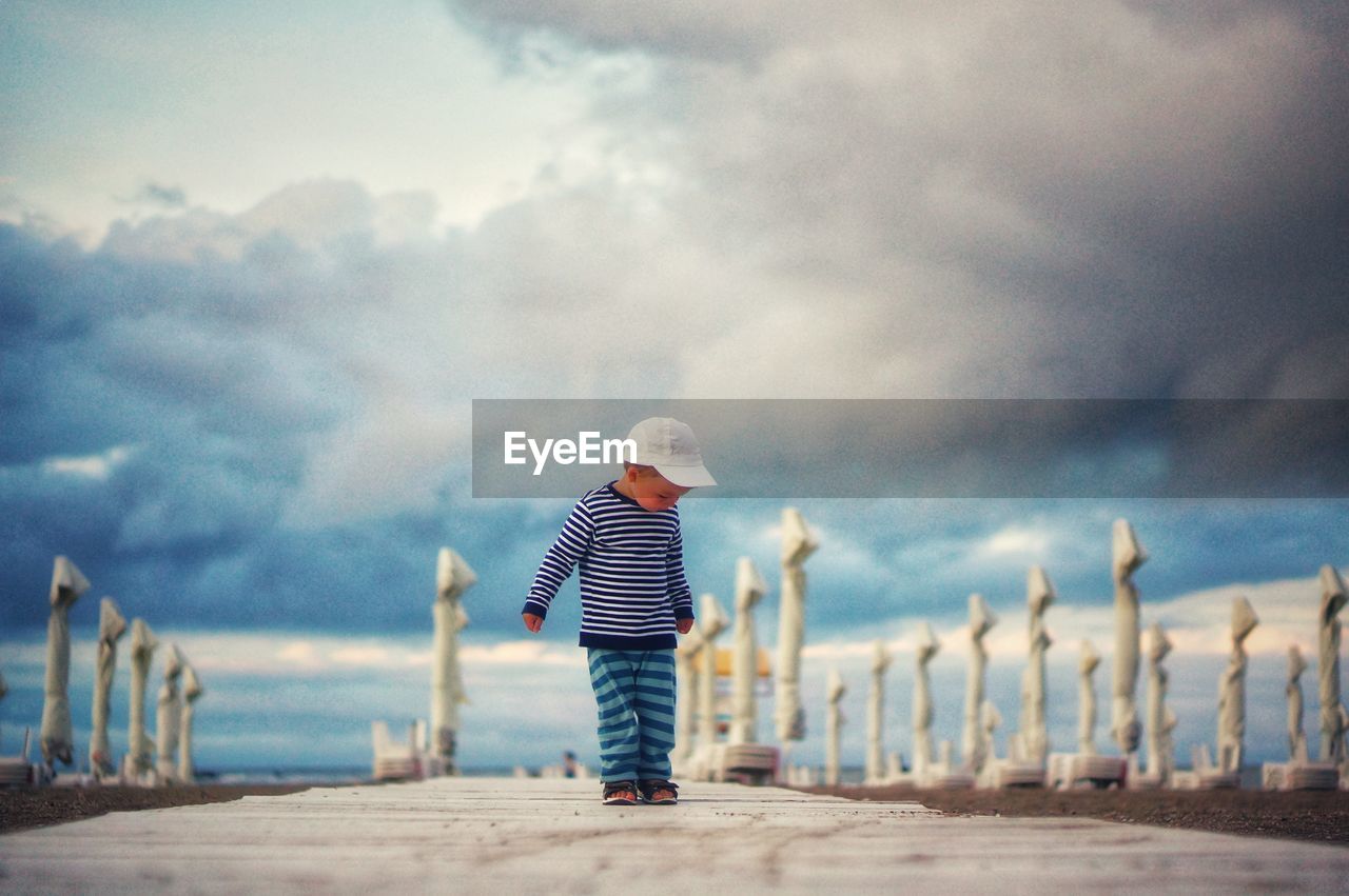 The little cute boy and the storm on the beach