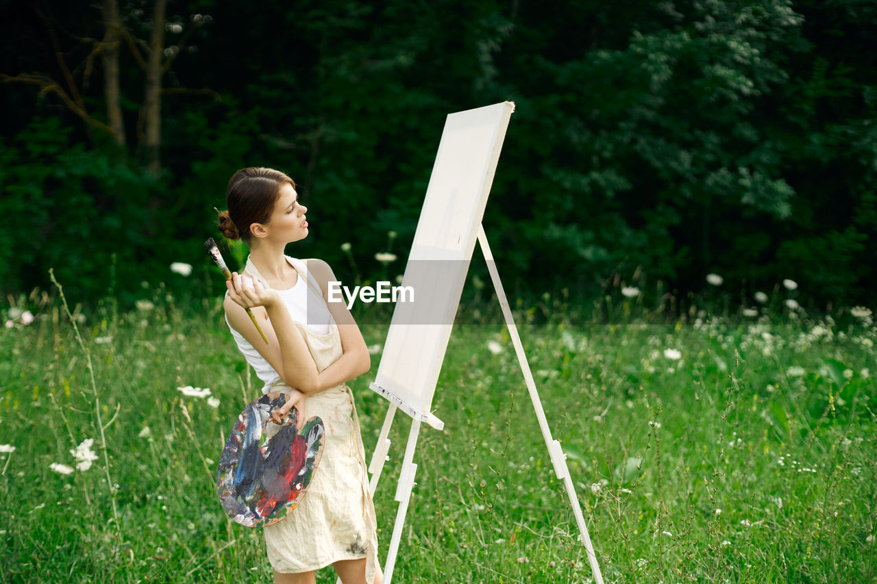 WOMAN WITH UMBRELLA ON FIELD