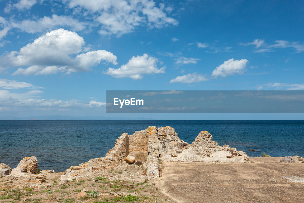 Ancient roman ruins on the seashore with cloudy sky