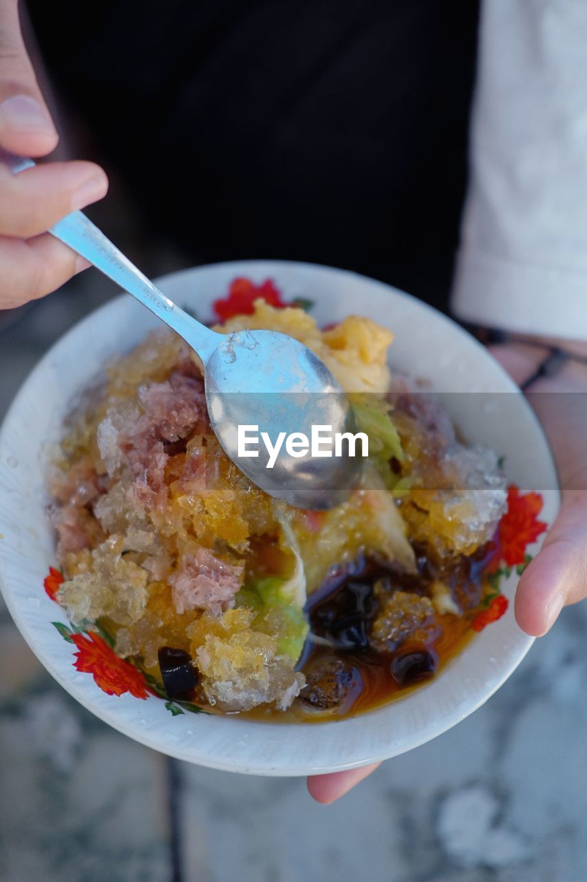 CLOSE-UP OF HAND HOLDING FOOD