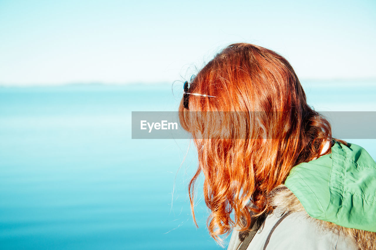 PORTRAIT OF WOMAN LOOKING AT SEA