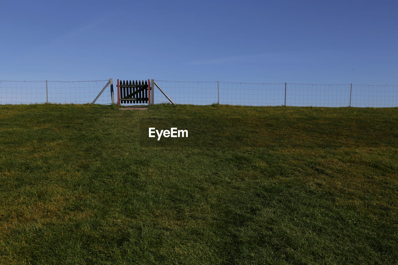Built structure on grassy field against clear sky