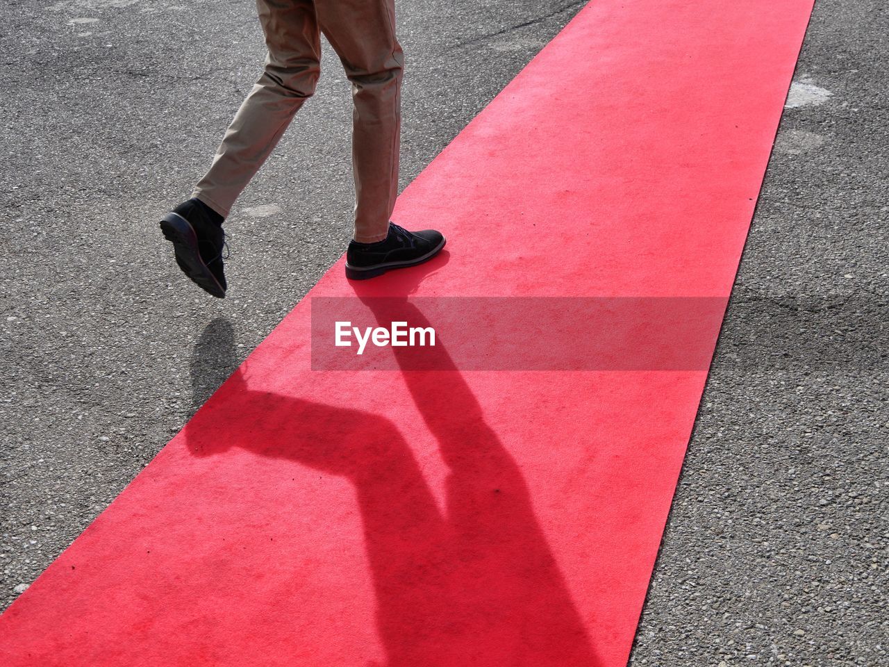 Low section of man walking on red carpet