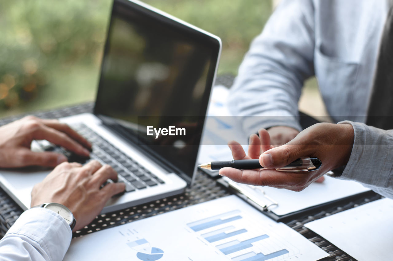Close-up of business colleagues working in office