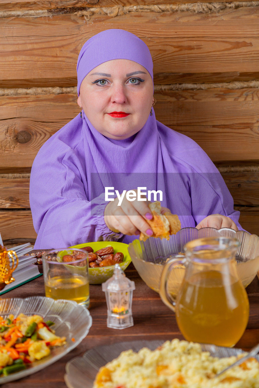 portrait of young woman eating food on table