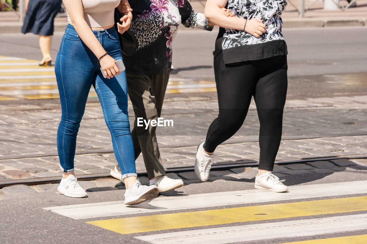 LOW SECTION OF PEOPLE WALKING ON FOOTPATH