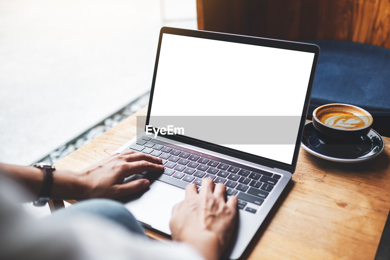 midsection of woman using laptop on table