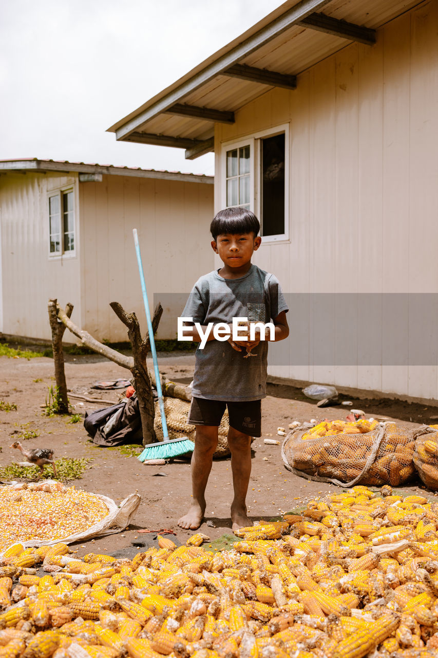 FULL LENGTH OF MAN STANDING BY HOUSE