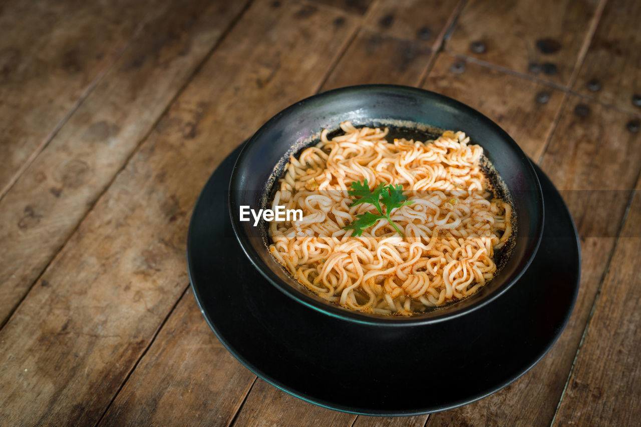 Instant noodles in a cup on the wooden floor, asian meal, 3 minutes