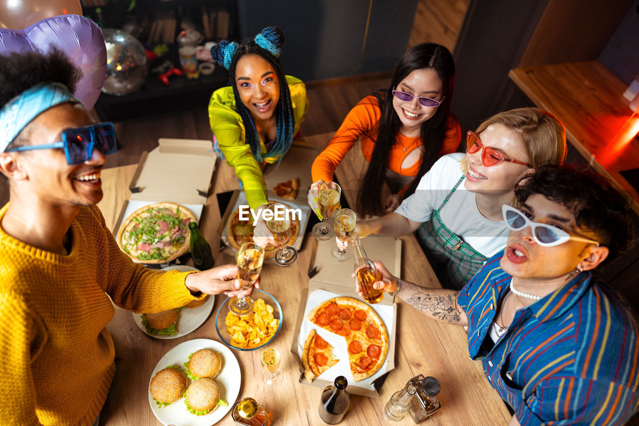 portrait of smiling friends with food at home