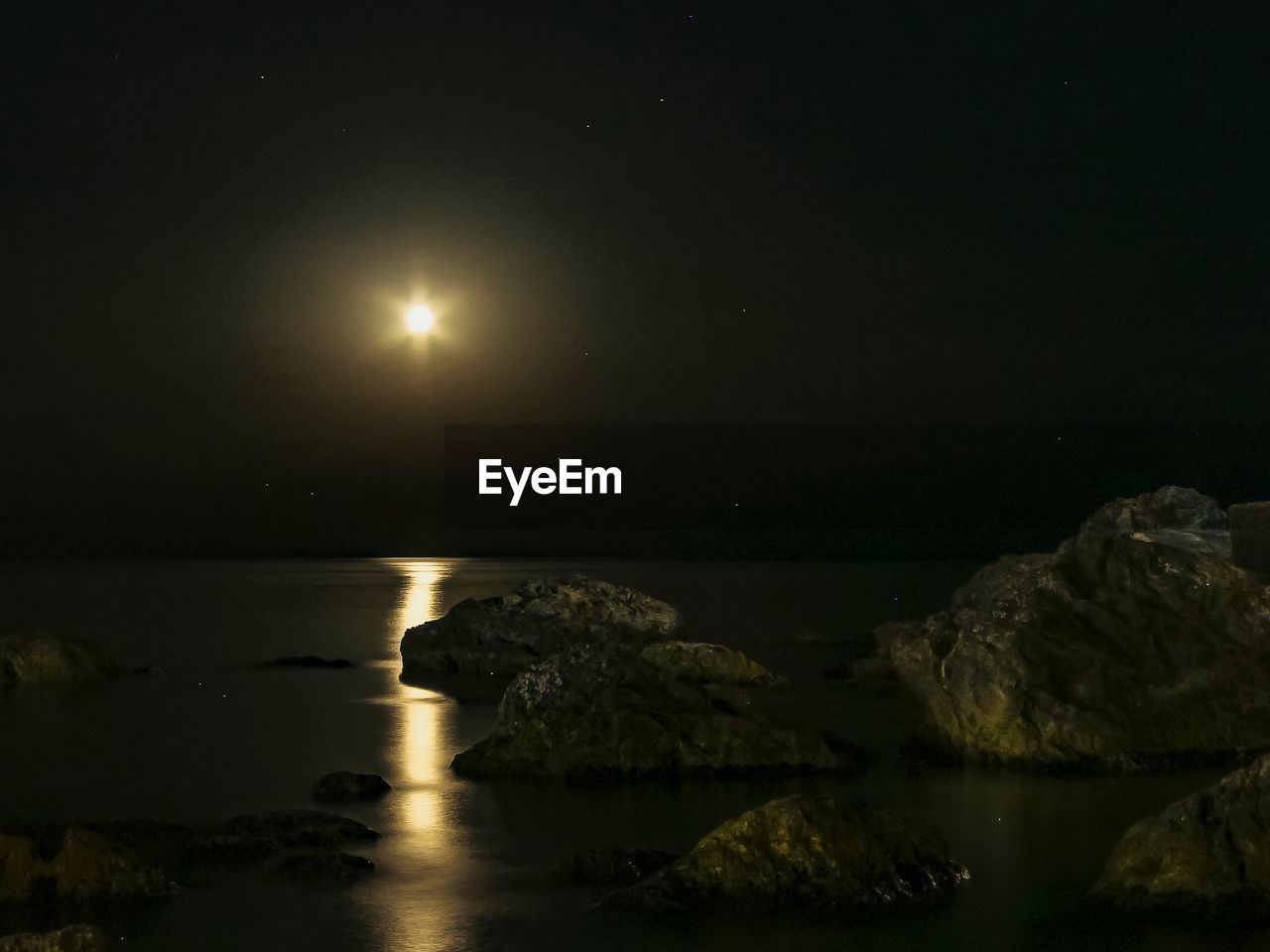 SCENIC VIEW OF SEA AND ILLUMINATED MOON AT NIGHT