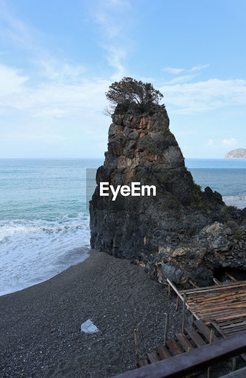 ROCKS ON SHORE AGAINST SKY