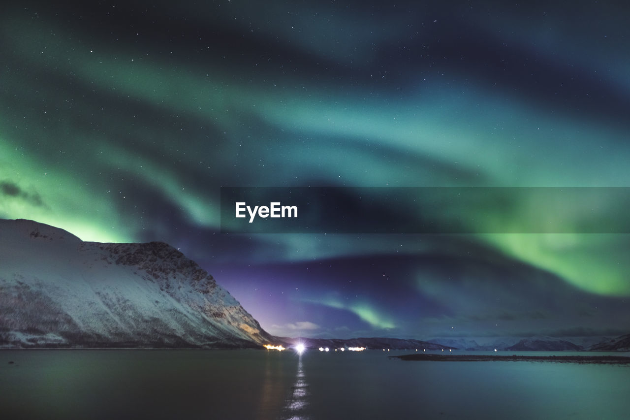 Scenic view of snowcapped mountains against sky at night