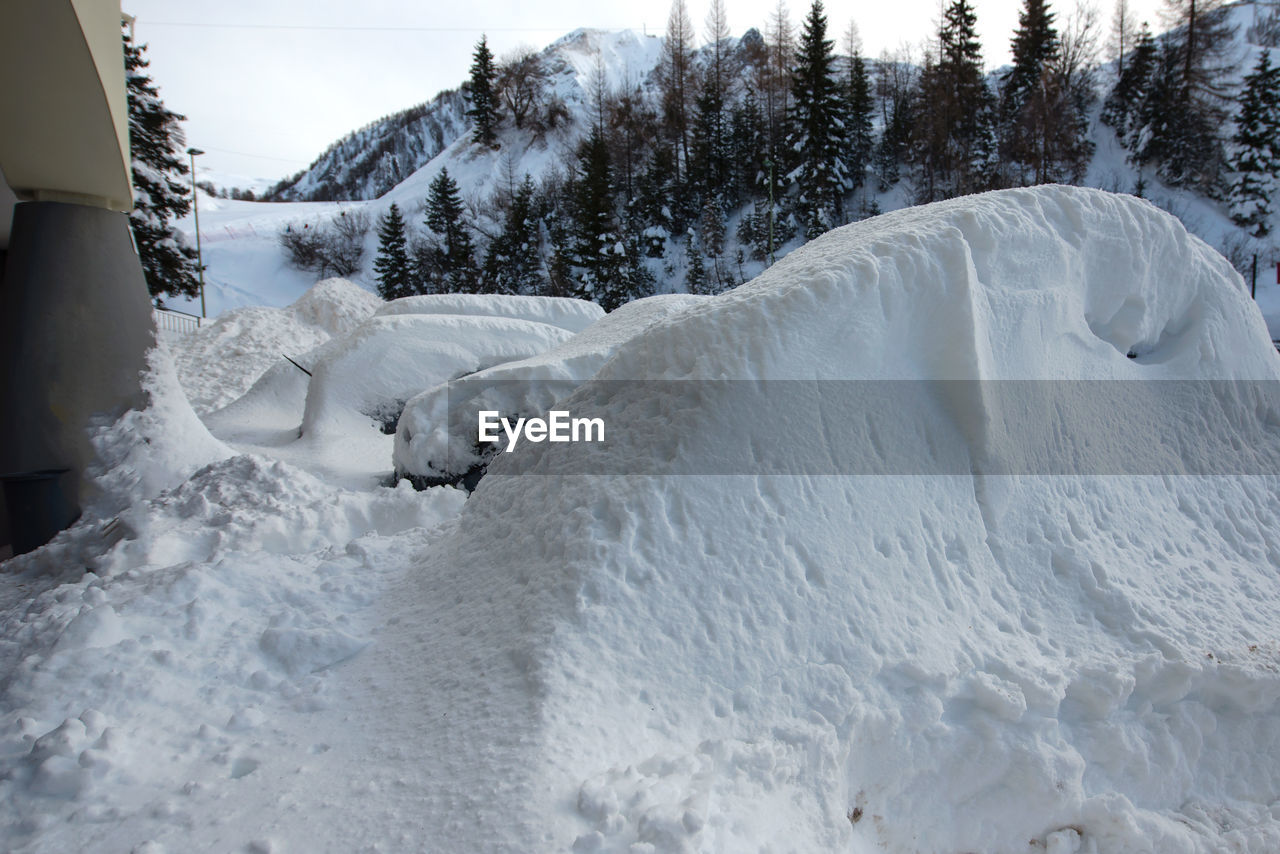 SCENIC VIEW OF SNOW COVERED FIELD AGAINST MOUNTAIN