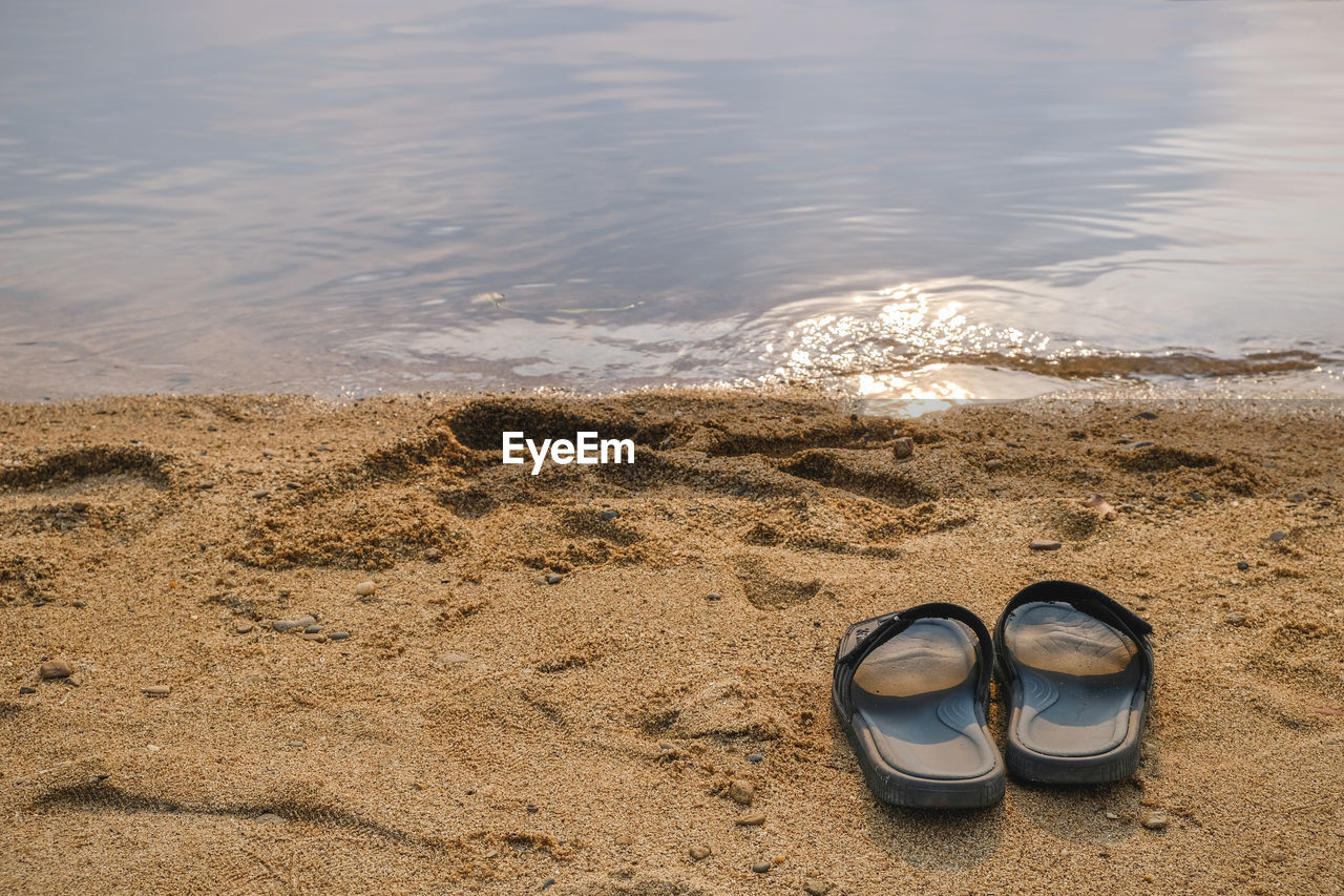 High angle view of shoes on sand at beach