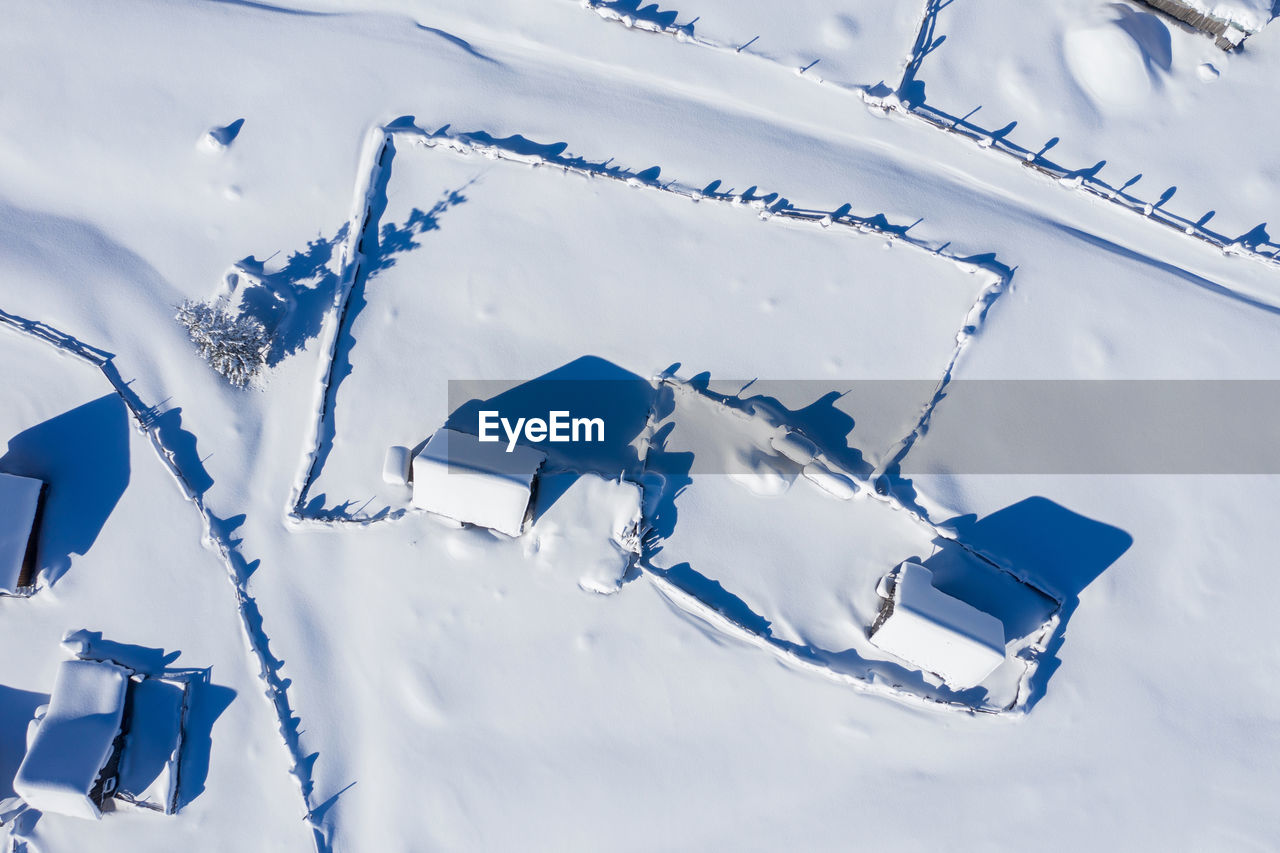 Snow covered remote village, homestead in the mountains. aerial drone view