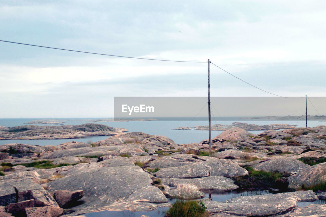 Rocks by sea against sky