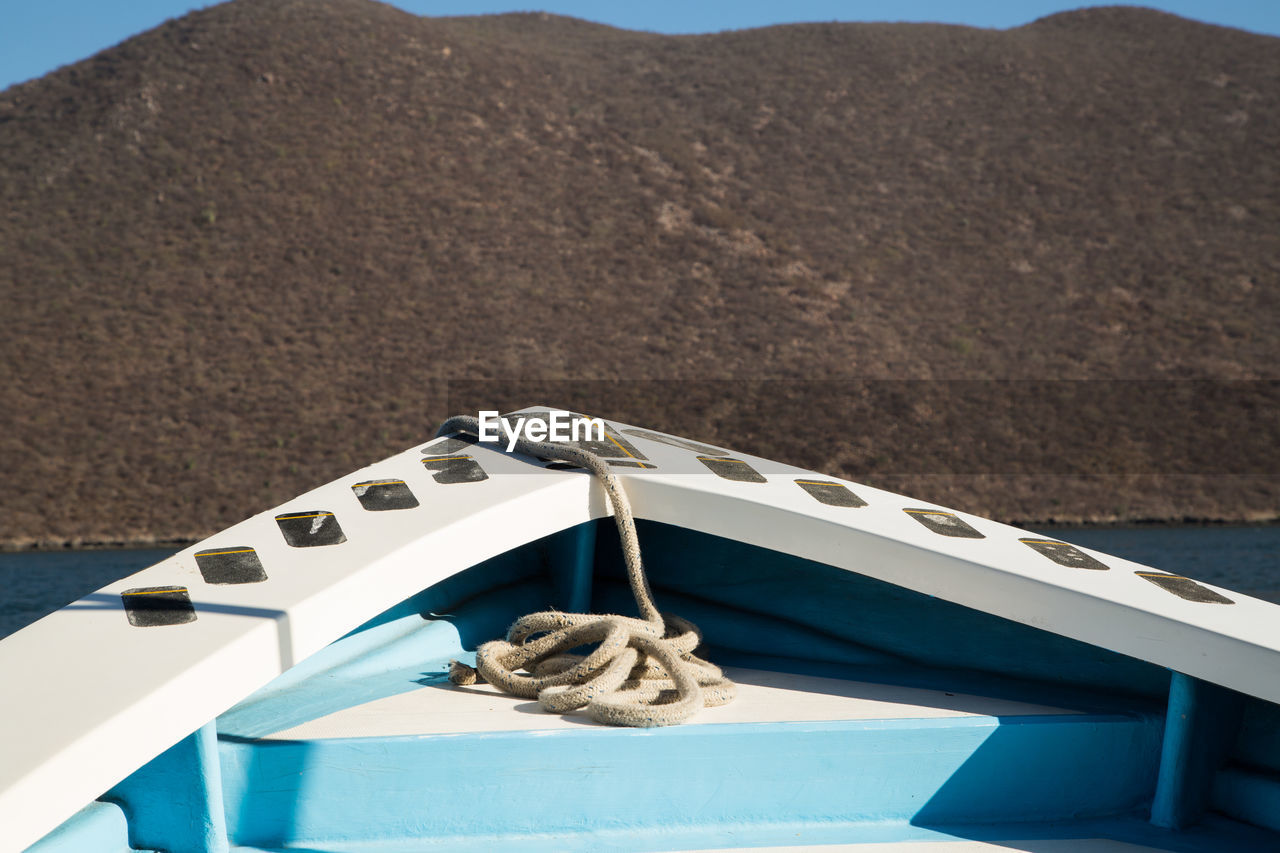 HIGH ANGLE VIEW OF INFORMATION SIGN ON TABLE AGAINST MOUNTAIN