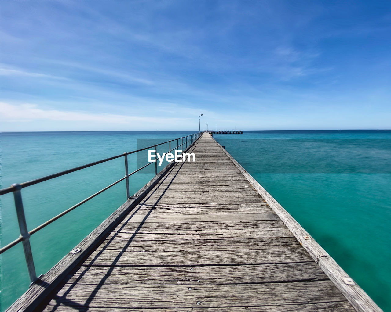 Pier over sea against blue sky